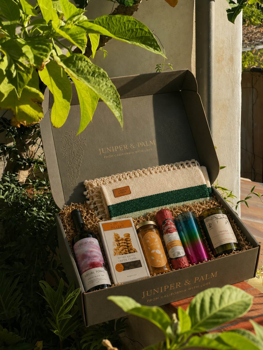 Open Juniper & Palm California artisan gift box with handwoven towel, artisan candle, honey and skincare bottles
